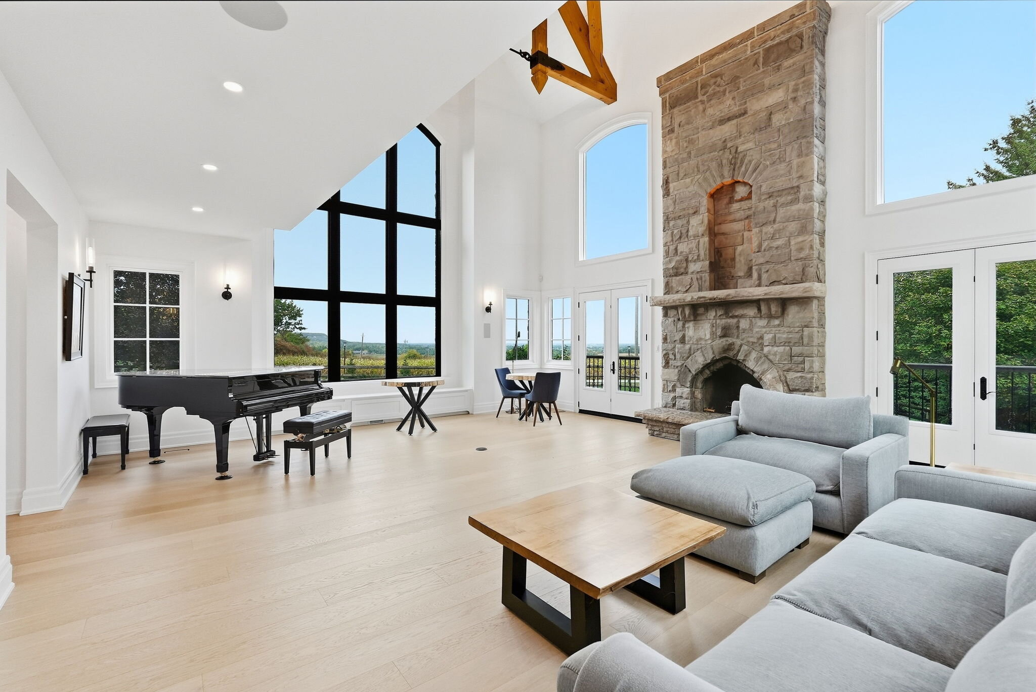 Great room with grand piano and limestone fireplace