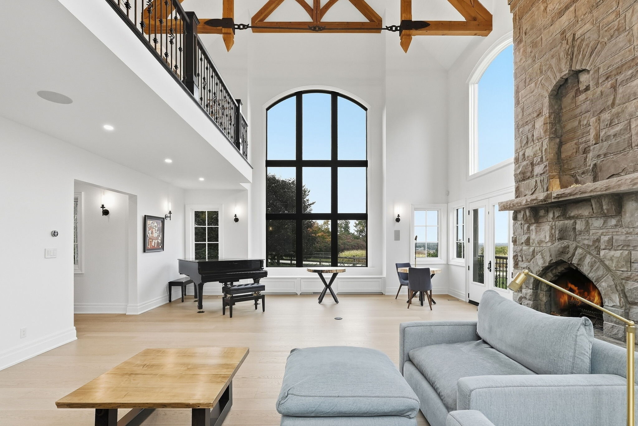 Two-storey great room with timber trusses and stone fireplace