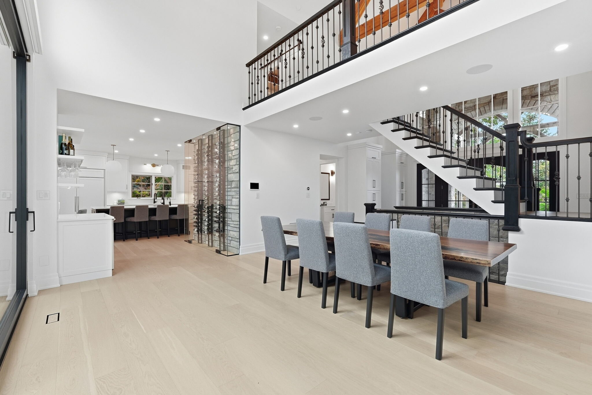 Dining area with glass wine-display feature and kitchen beyond